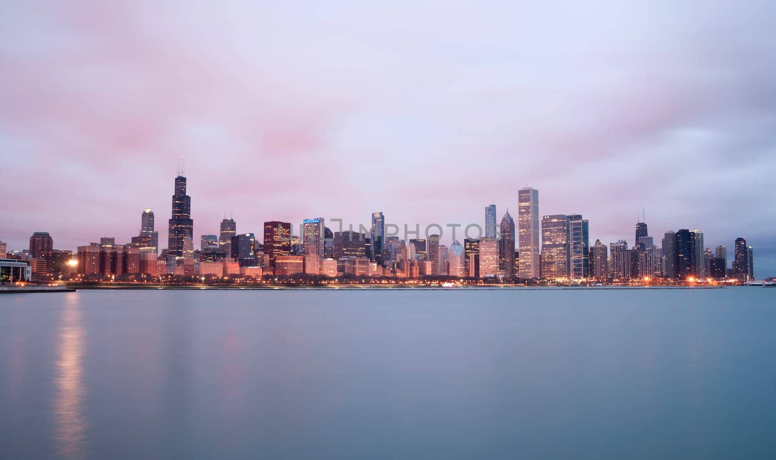 A beautiful pink sunrise lights the long downtown Chicago skyline