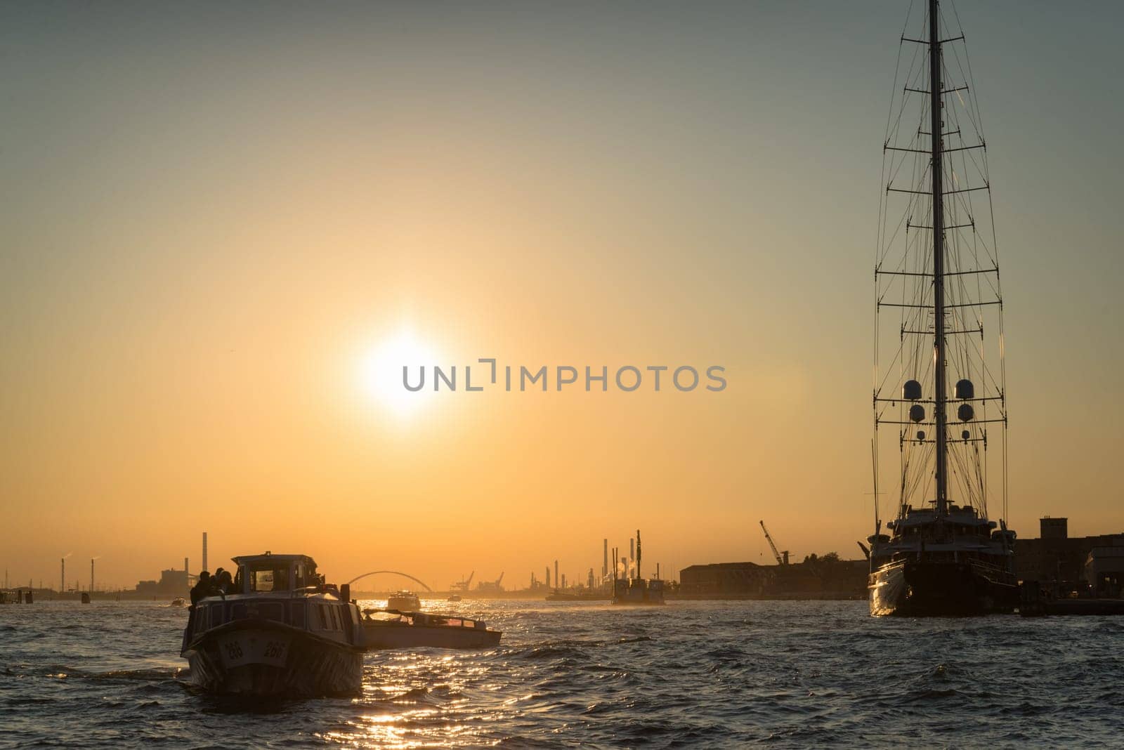 Luxury sailing yacht boat docked in Port of Venice, Italy with other cruise ship liners and Venetian skyline on Giudecca Canal on summer day