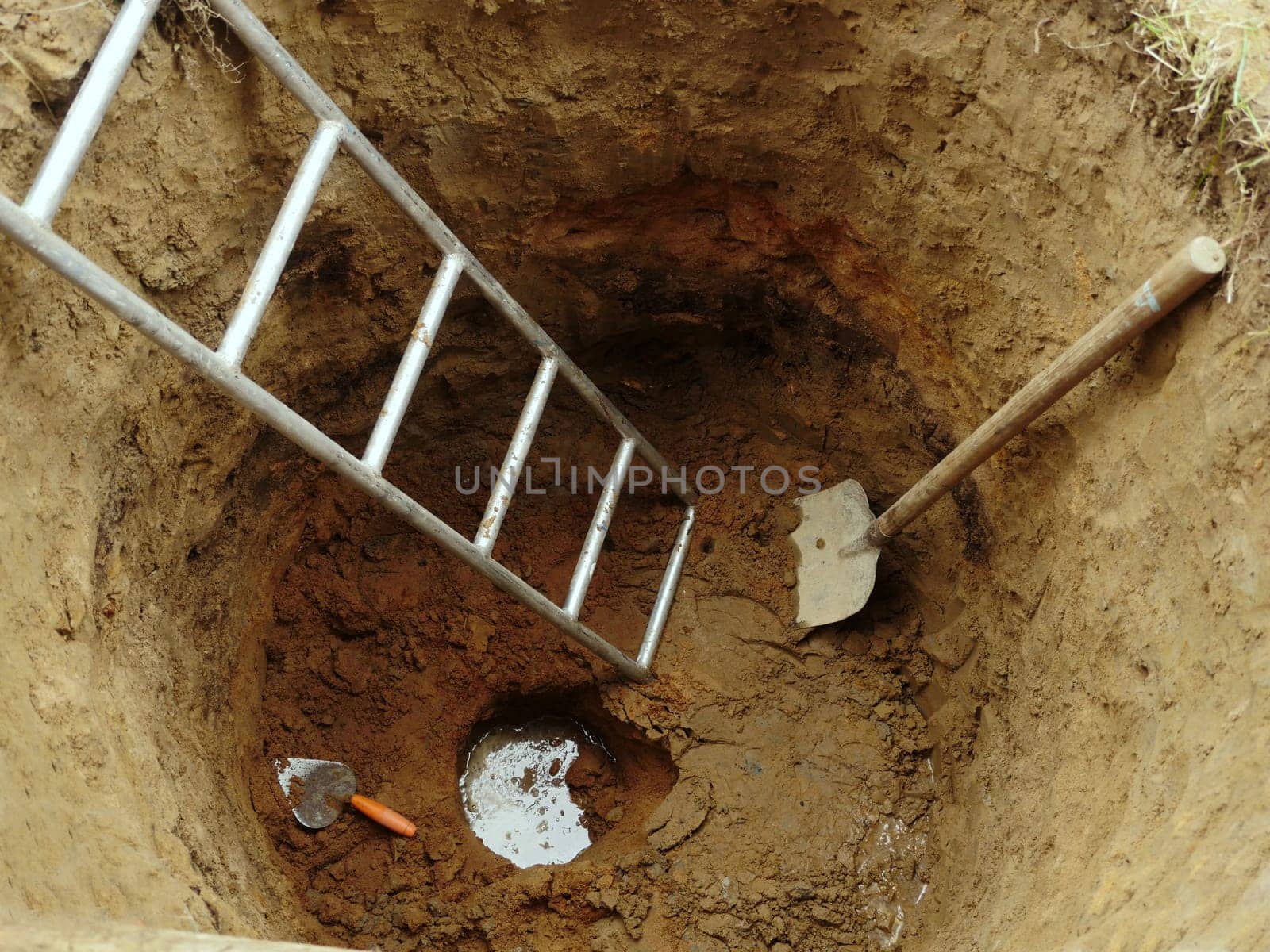 water well with hand construction tool ground top view, water has appeared at the bottom