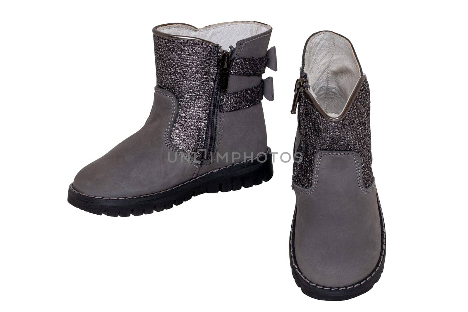 Winter boots. Close-up of a pair elegant gray silver leather winter boots lined with white leather. Girls winter shoe fashion new trends isolated on a white background. Macro photograph.