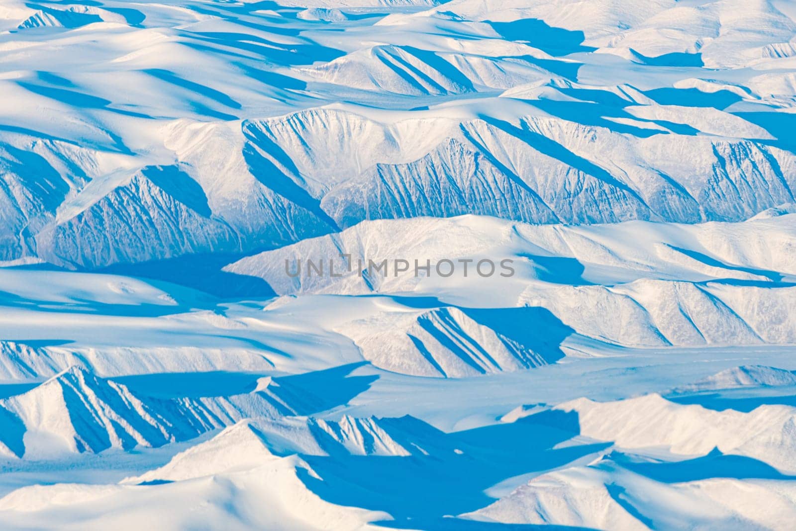 Snow mountains and planes of Greenland. View from plane.