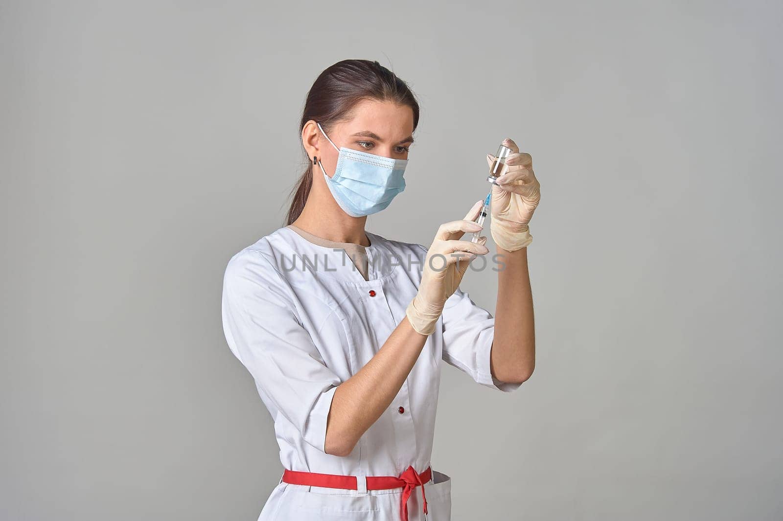 A nurse taking medicine into a syringe from a bottle close-up. . High quality photo