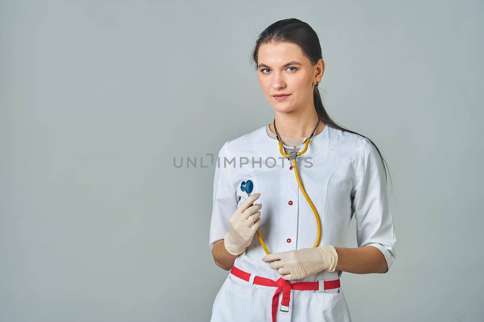 a young doctor in a white coat with a stethoscope around his neck. High quality photo
