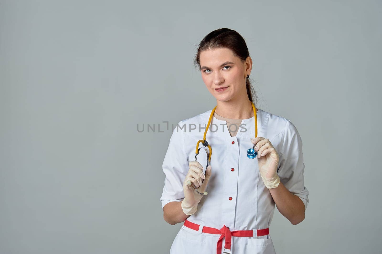 a young doctor in a white lab coat with a yellow stethoscope slung over his neck. High quality photo