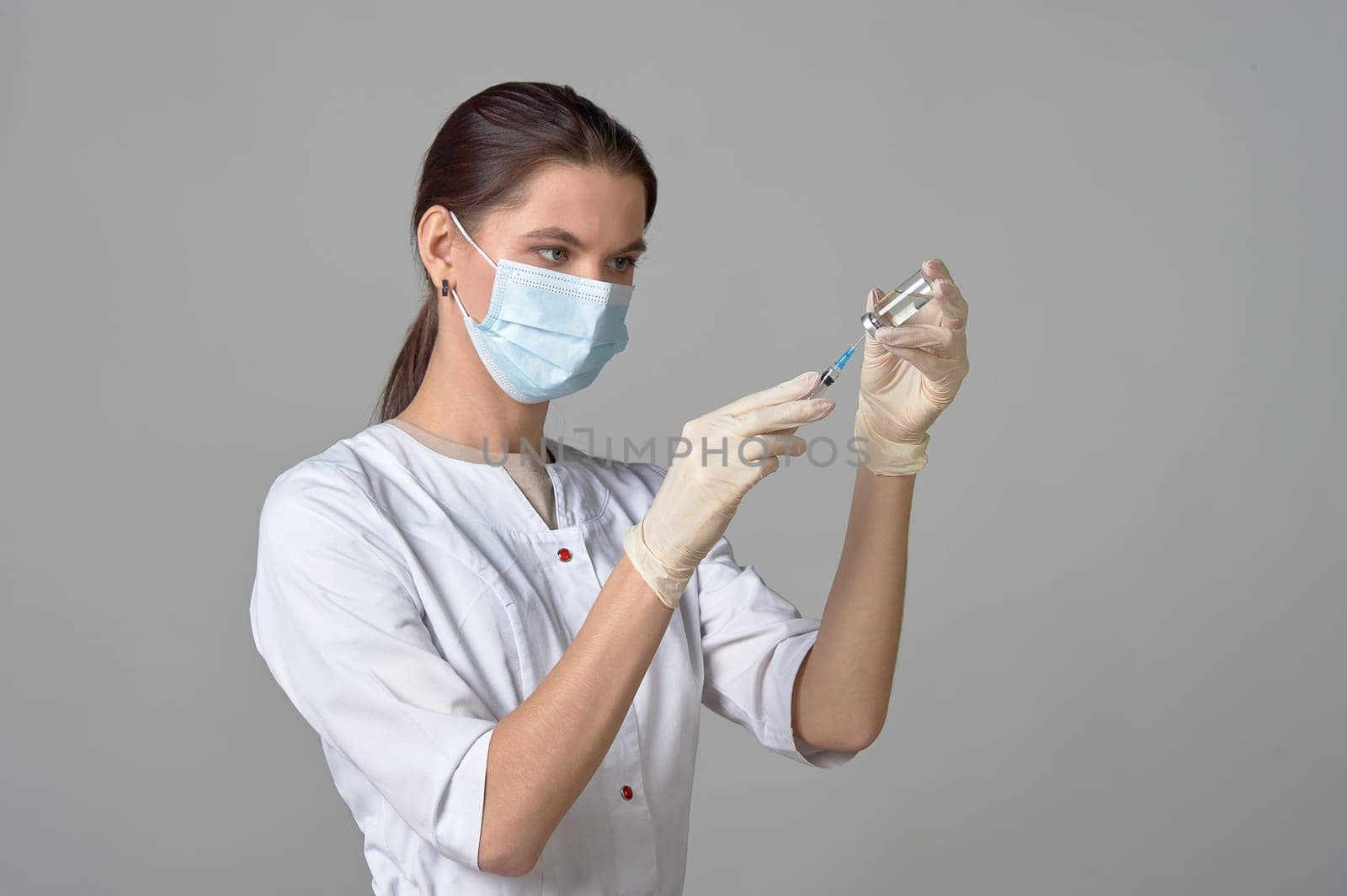 A nurse taking medicine into a syringe from a bottle close-up. . High quality photo