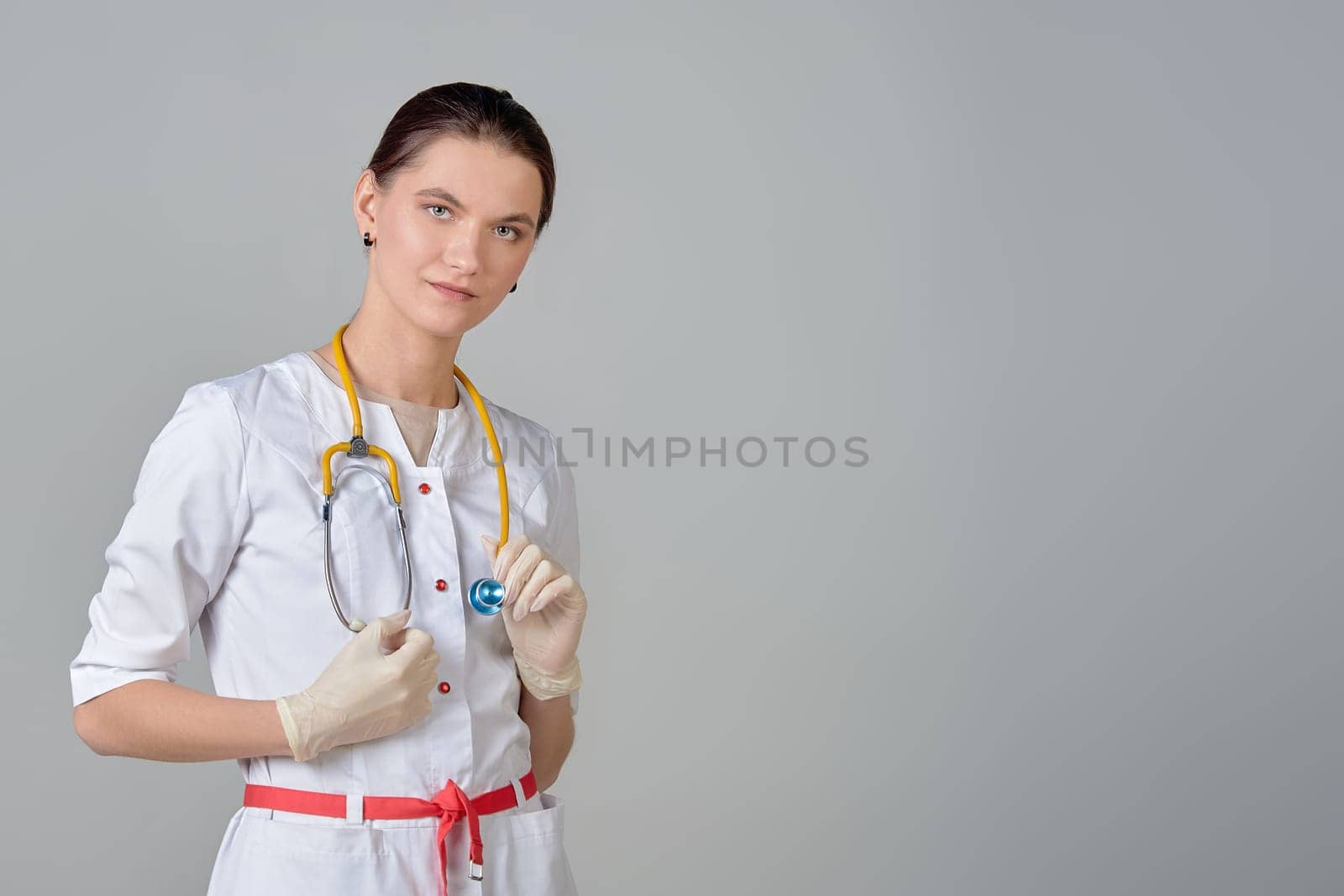 A young doctor in a white coat with a stethoscope, space for text. High quality photo