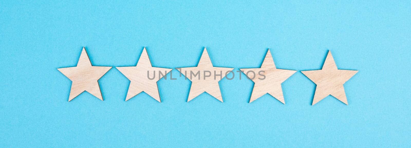 Five stars on a colored background, hand put the last star in the row, rating, giving feedback