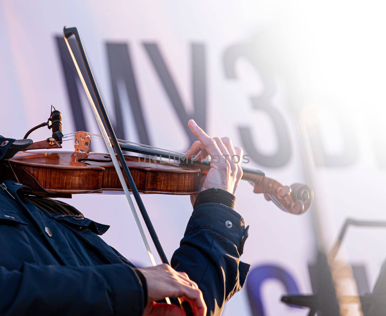 The street musician violin plays music outdoors