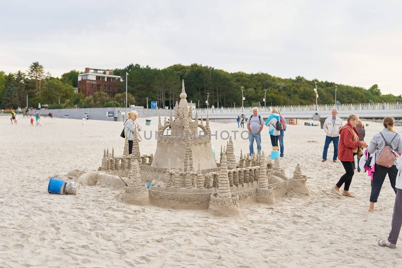 Holidaymakers admire a sandcastle on the beach of Kolobrzeg on the Polish coast of the Baltic Sea