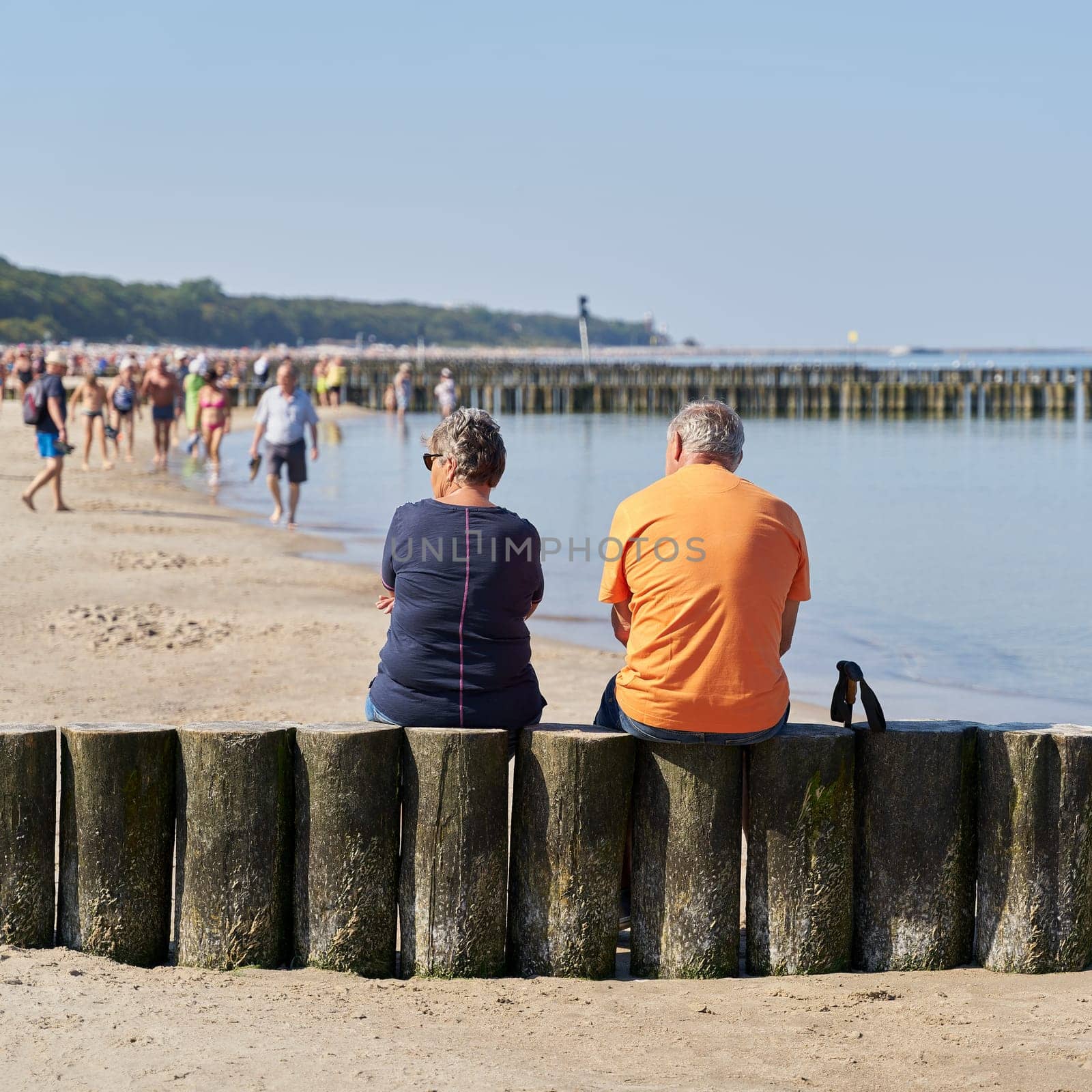 Couple on a breakwater on the beach of Kolobrzeg on the Baltic Sea in Poland