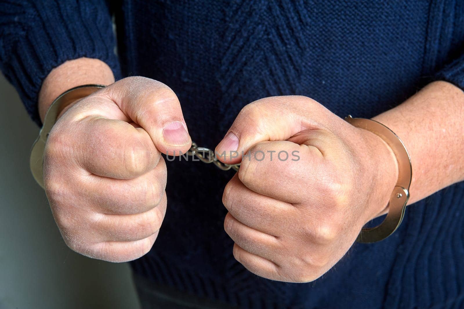 Men's hands in handcuffs close up. High quality photo