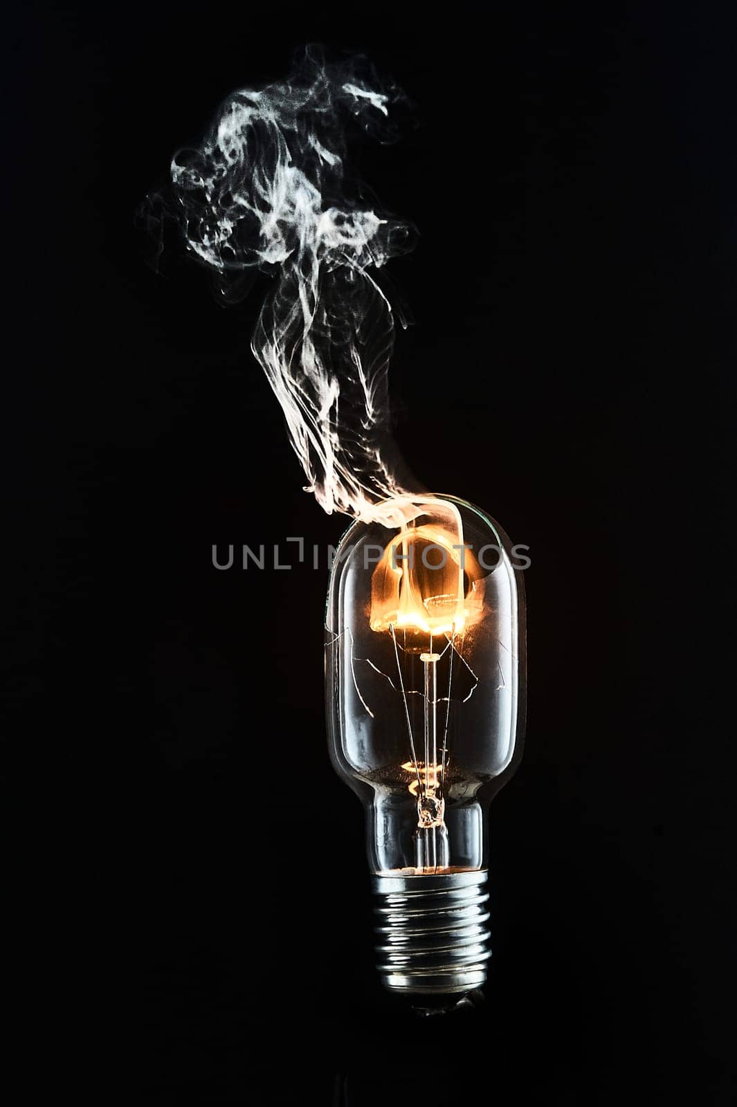 A broken incandescent light bulb is lit. High quality photo