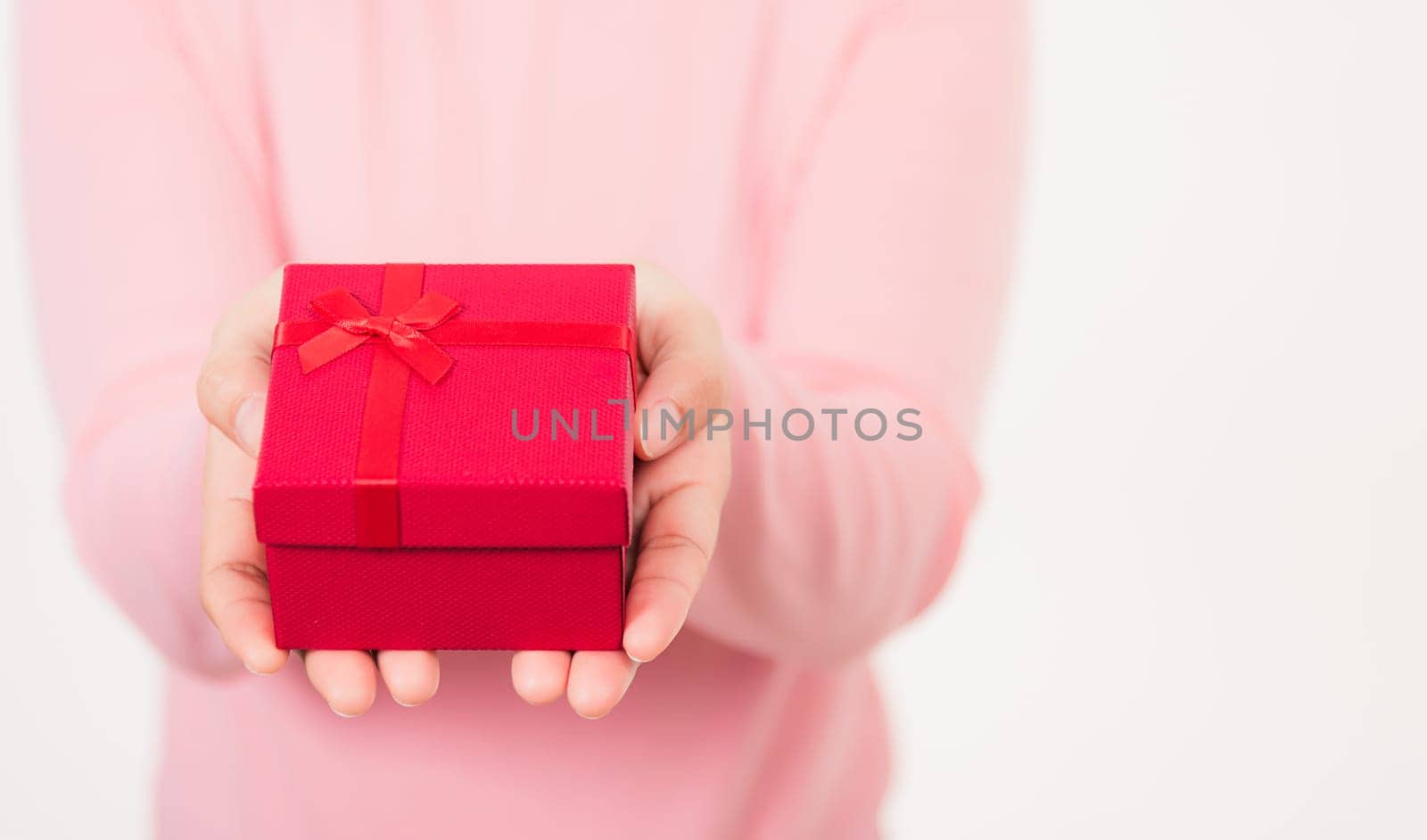 Valentine Day. Female beauty hands holding small gift package box present wrapped paper with ribbon isolated on white background, Christmas, New year, Birthday holiday background concept