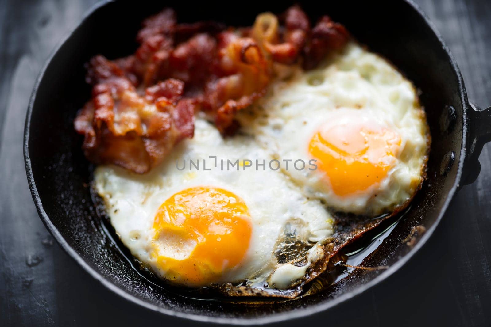 close up of pan of bacon fat  fried eggs breakfast