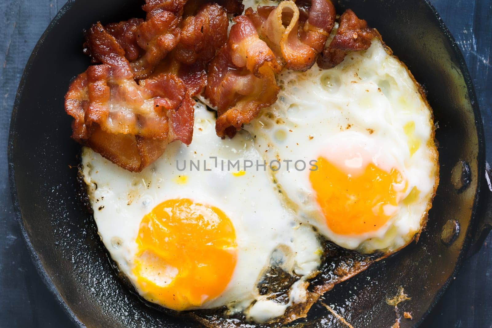 close up of pan of bacon fat  fried eggs breakfast