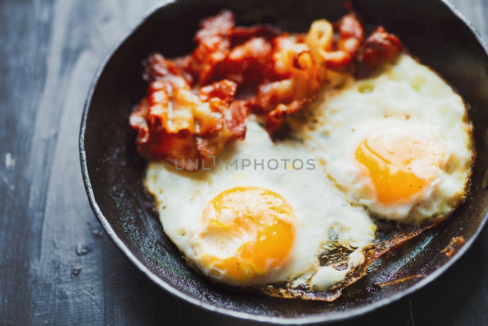 close up of pan of bacon fat  fried eggs breakfast