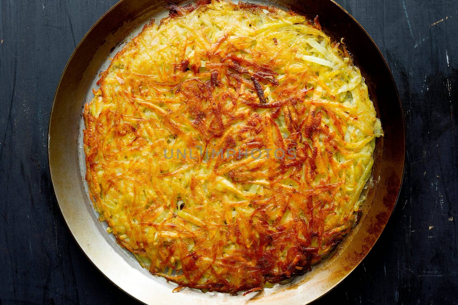 close up of a pan of golden swiss rosti fried potato pancake