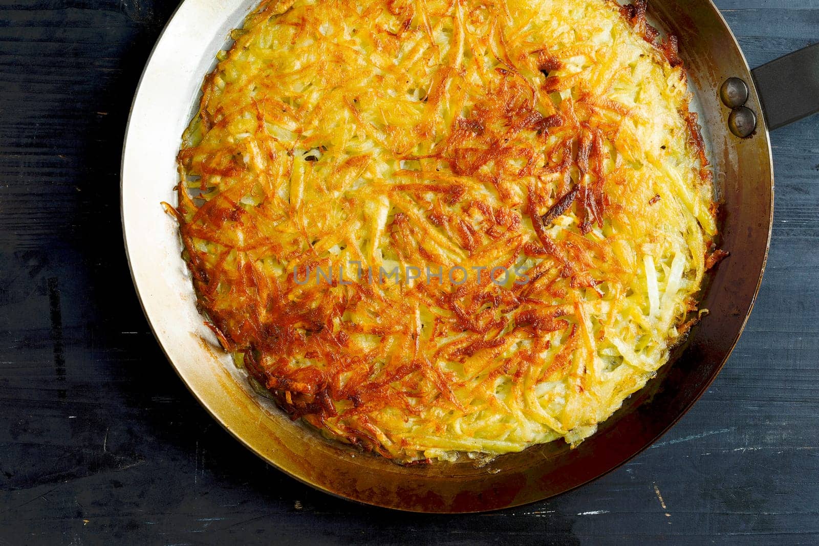 close up of a pan of golden swiss rosti fried potato pancake