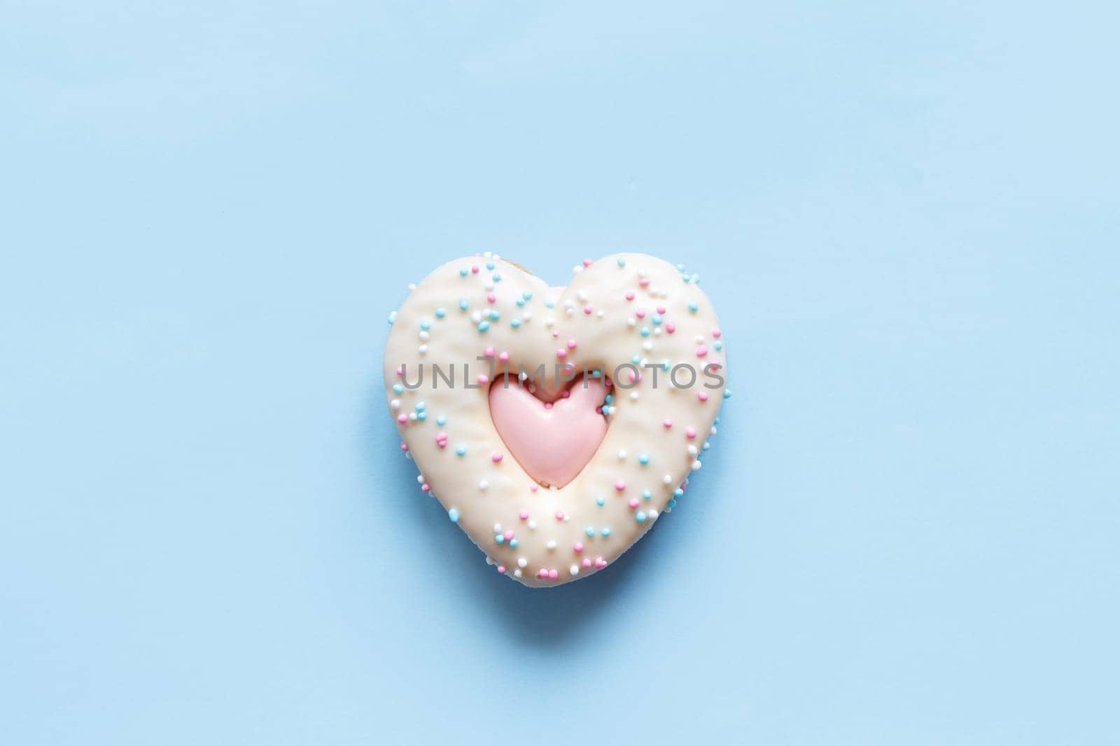 Flat lay of two heart shaped gingerbread cookies with sprinkles and icing on pink background. Top view of tasty Valentine's Day bakery, homemade bakery for romantic holiday