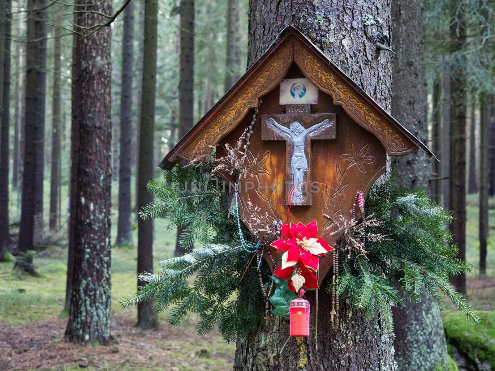 Memorial cross on a tree trunk in the forest