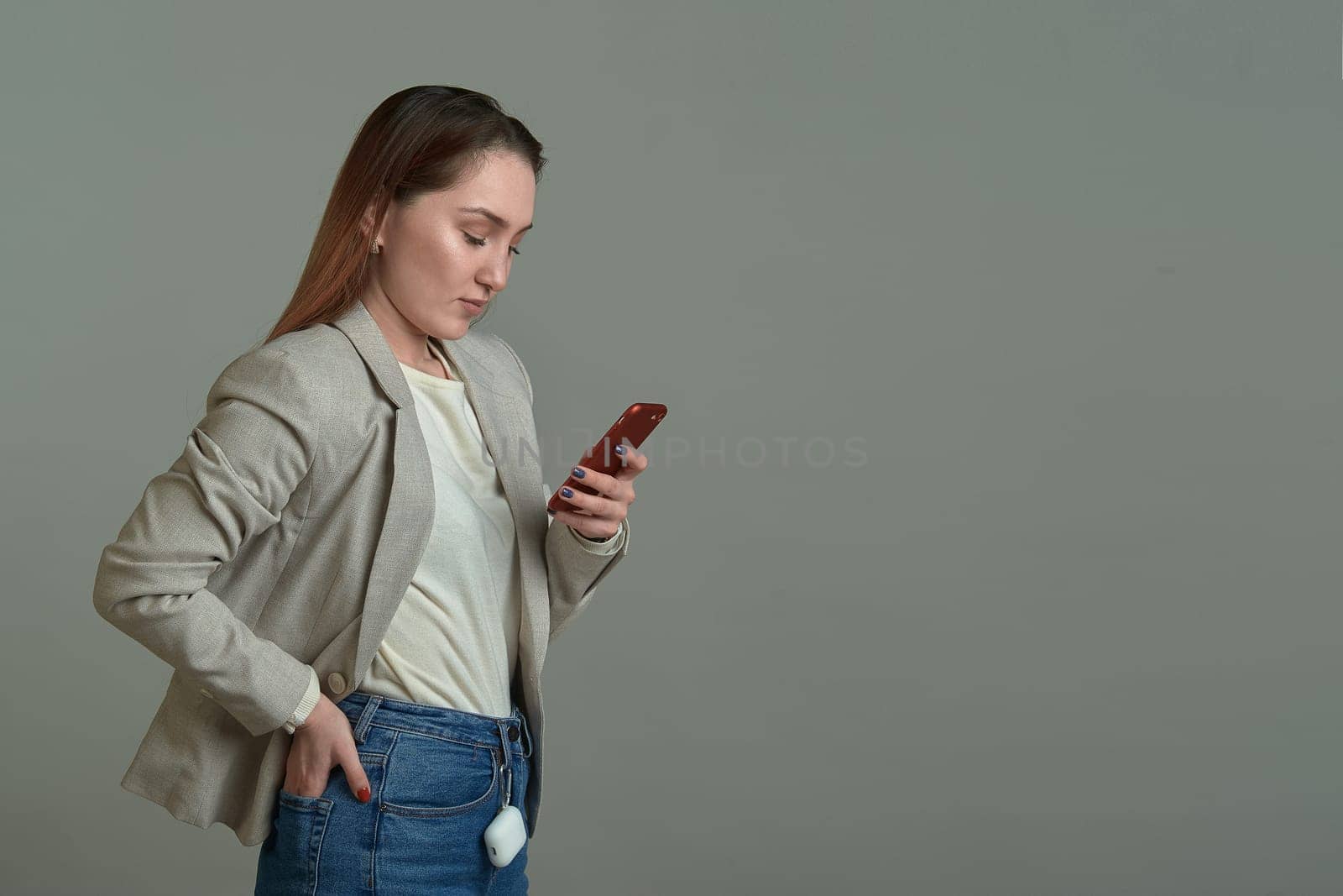cute girl with a phone in her hands on a gray background. High quality photo