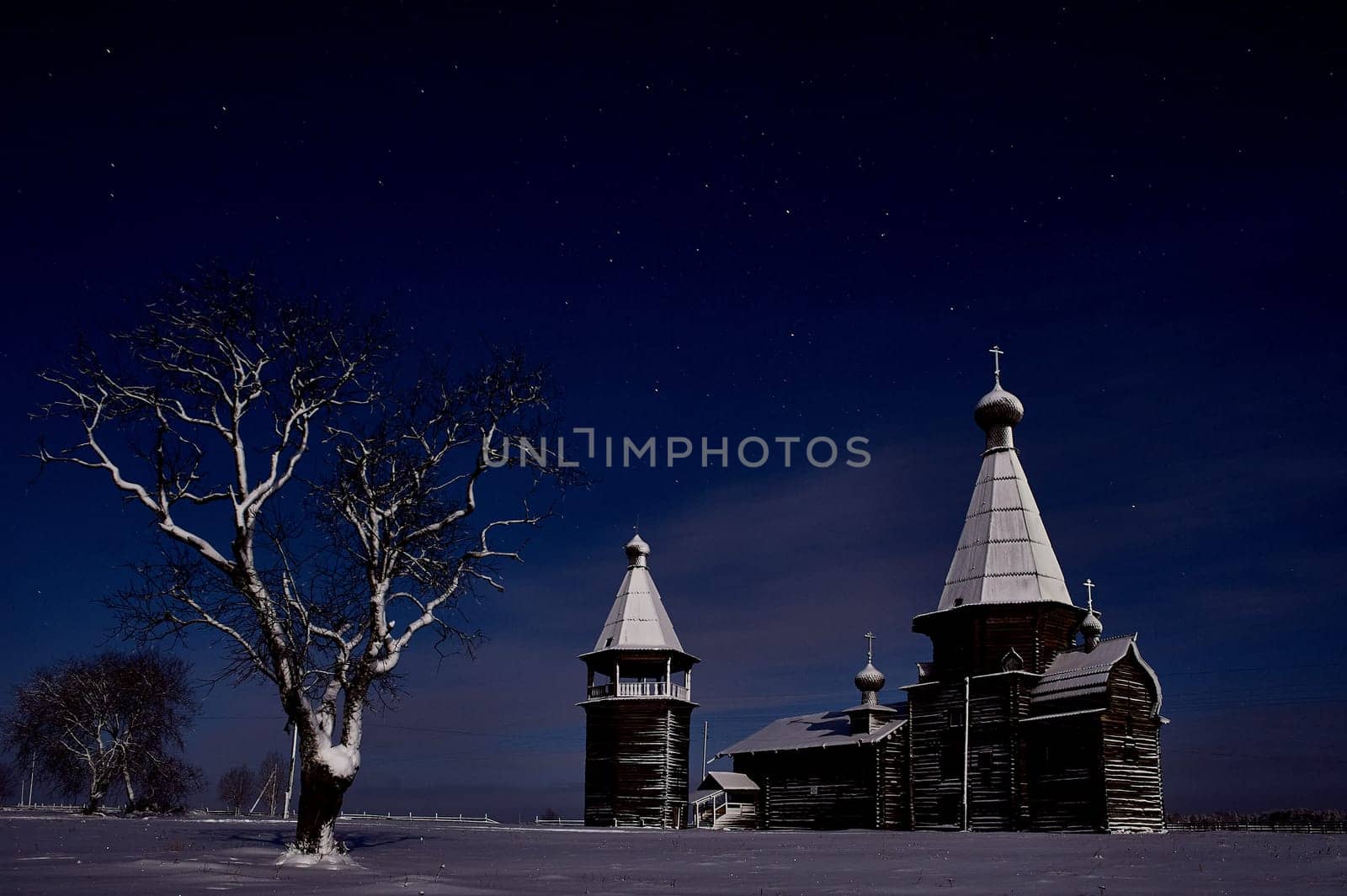 Wooden ancient temple at night in winter on a tree background. High quality photo