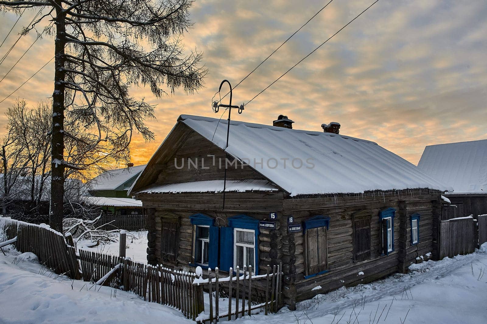 Village hut in winter at sunset. High quality photo