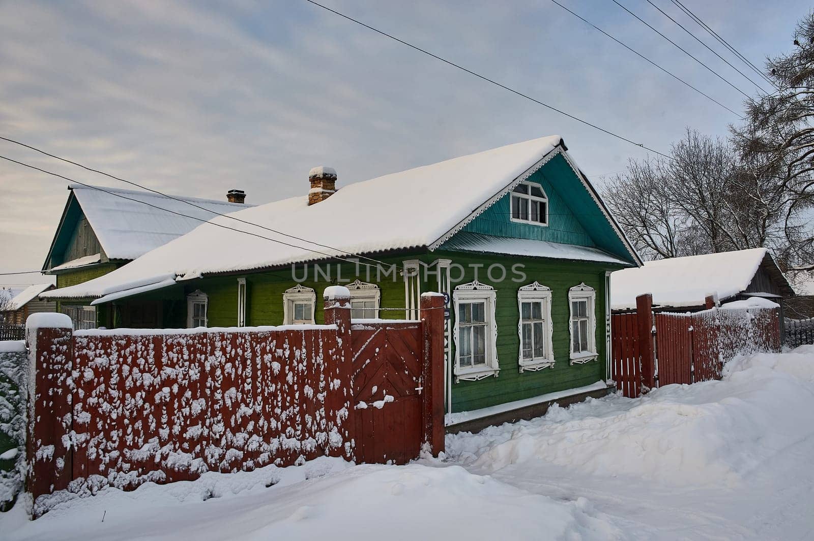 Village hut in winter on the background of the temple. High quality photo