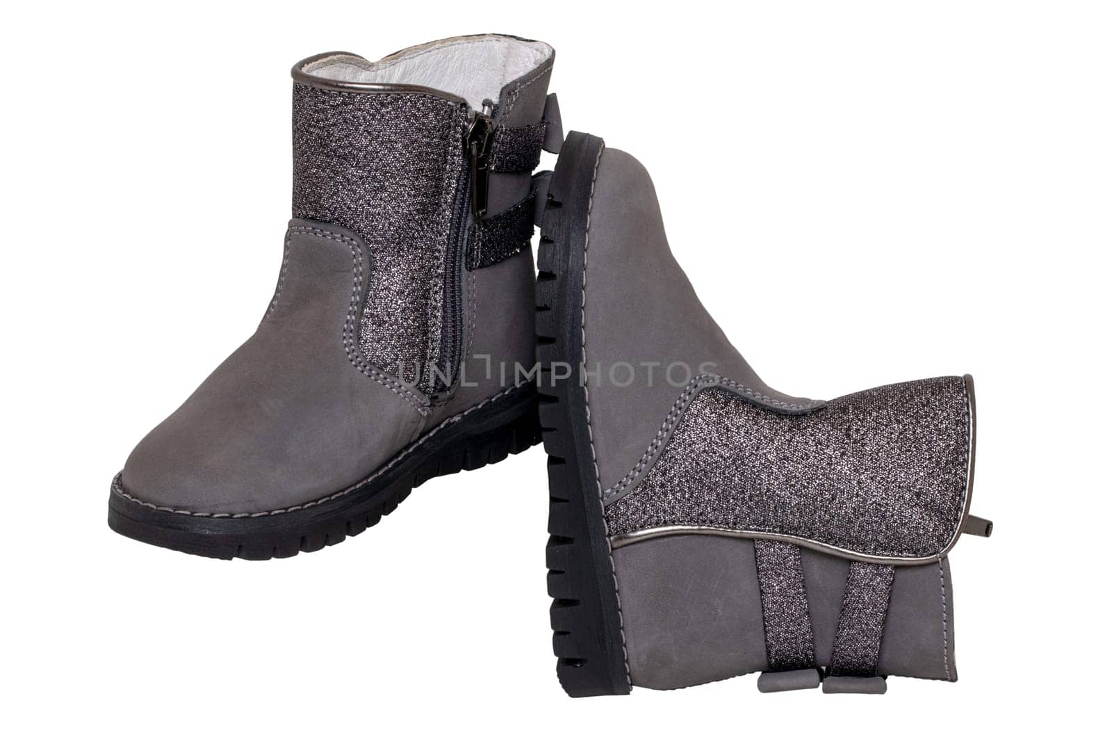 Winter boots. Close-up of a pair elegant gray silver leather winter boots lined with white leather. Girls winter shoe fashion new trends isolated on a white background. Clipping path. Macro.