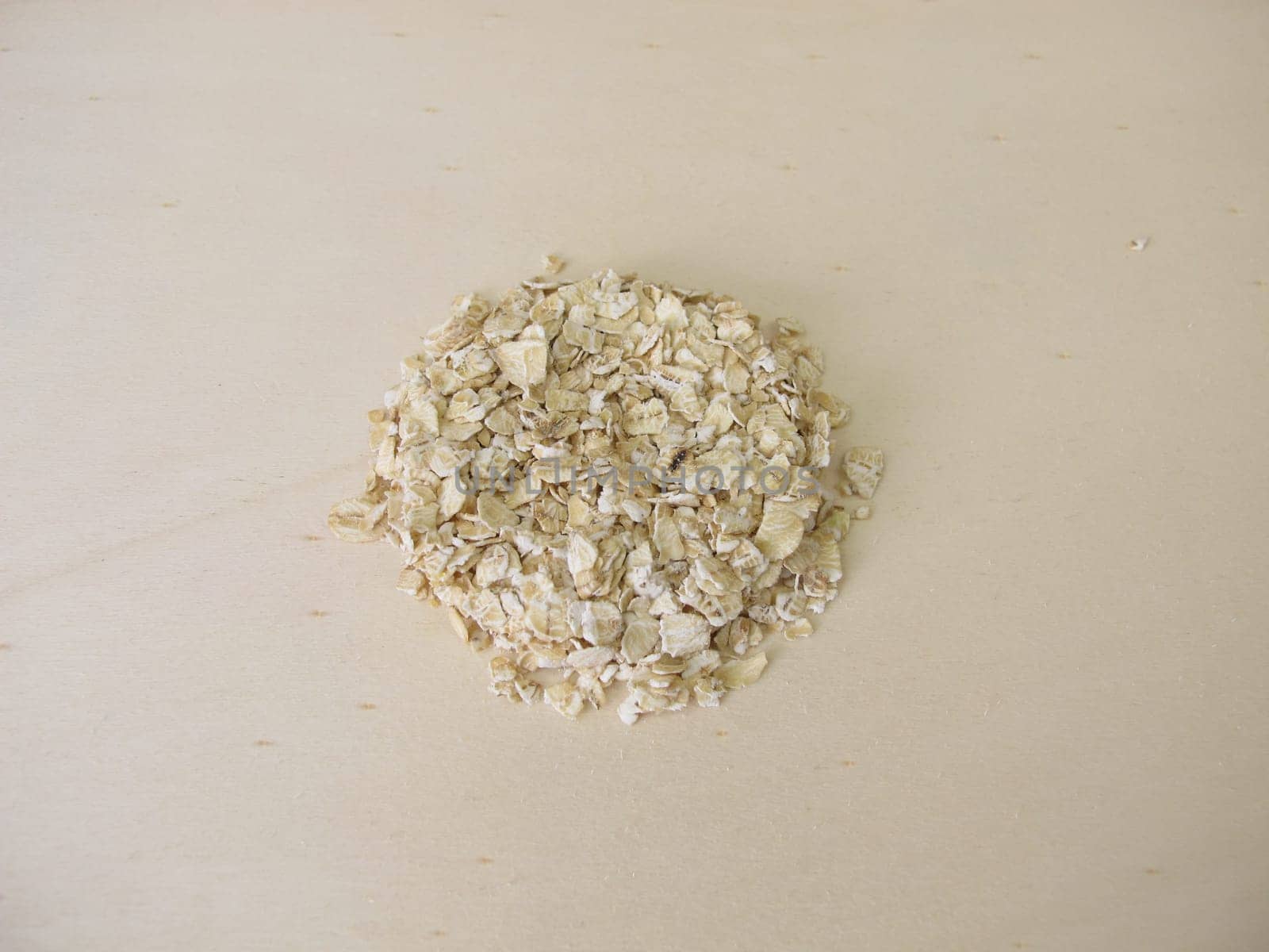 Fine rolled oats flakes on a wooden board