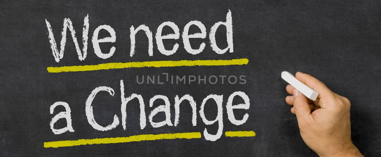 Text written on a blackboard - We need a change