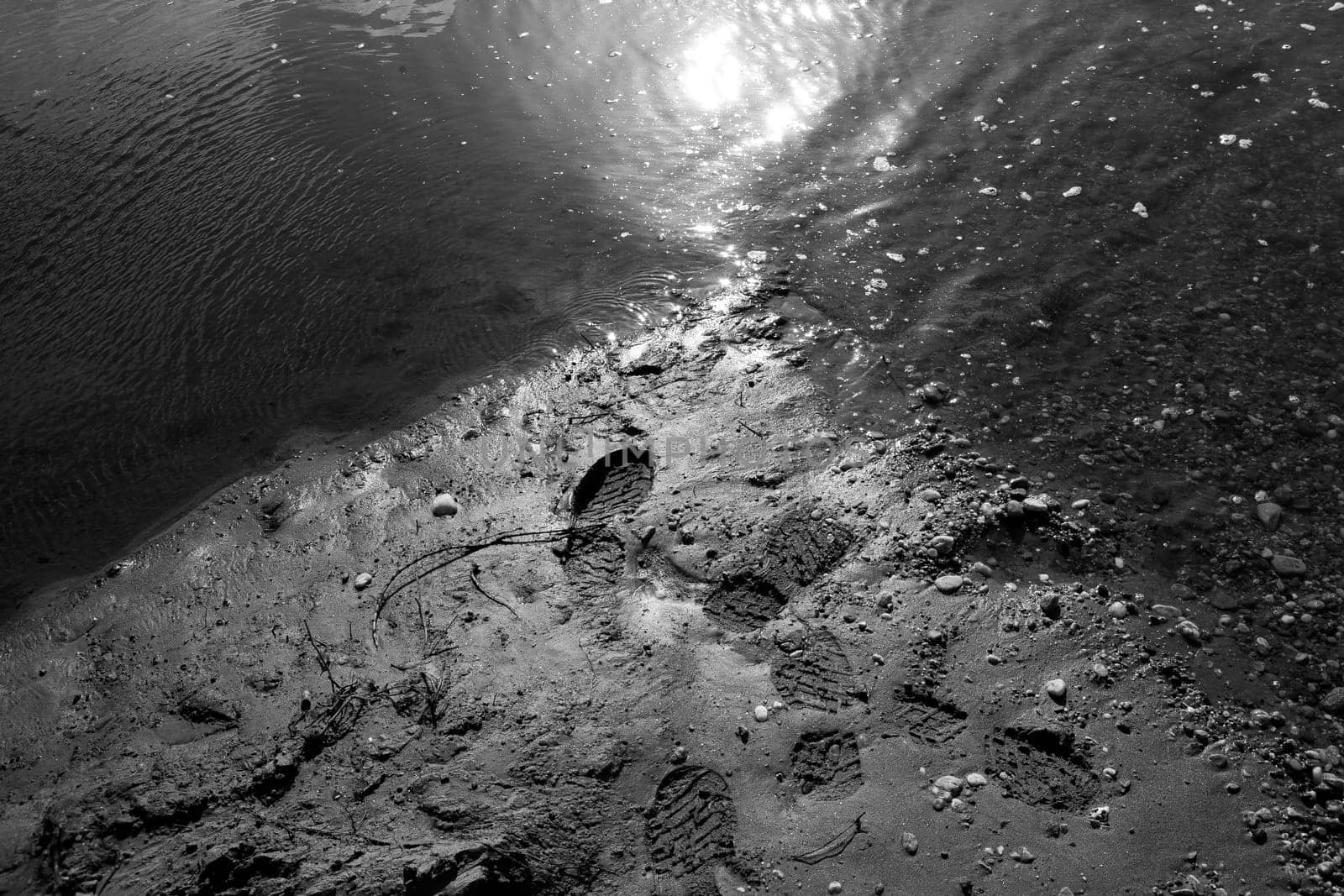 High angle shot of a wet sandy beach with footprints