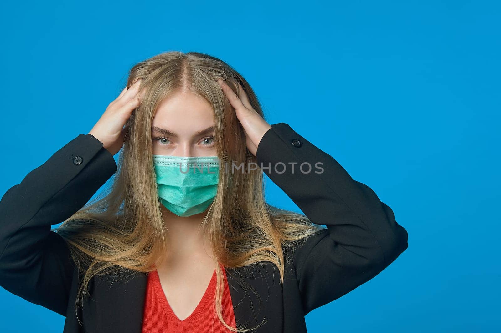 Business woman with a medical mask on her face holding her head. High quality photo