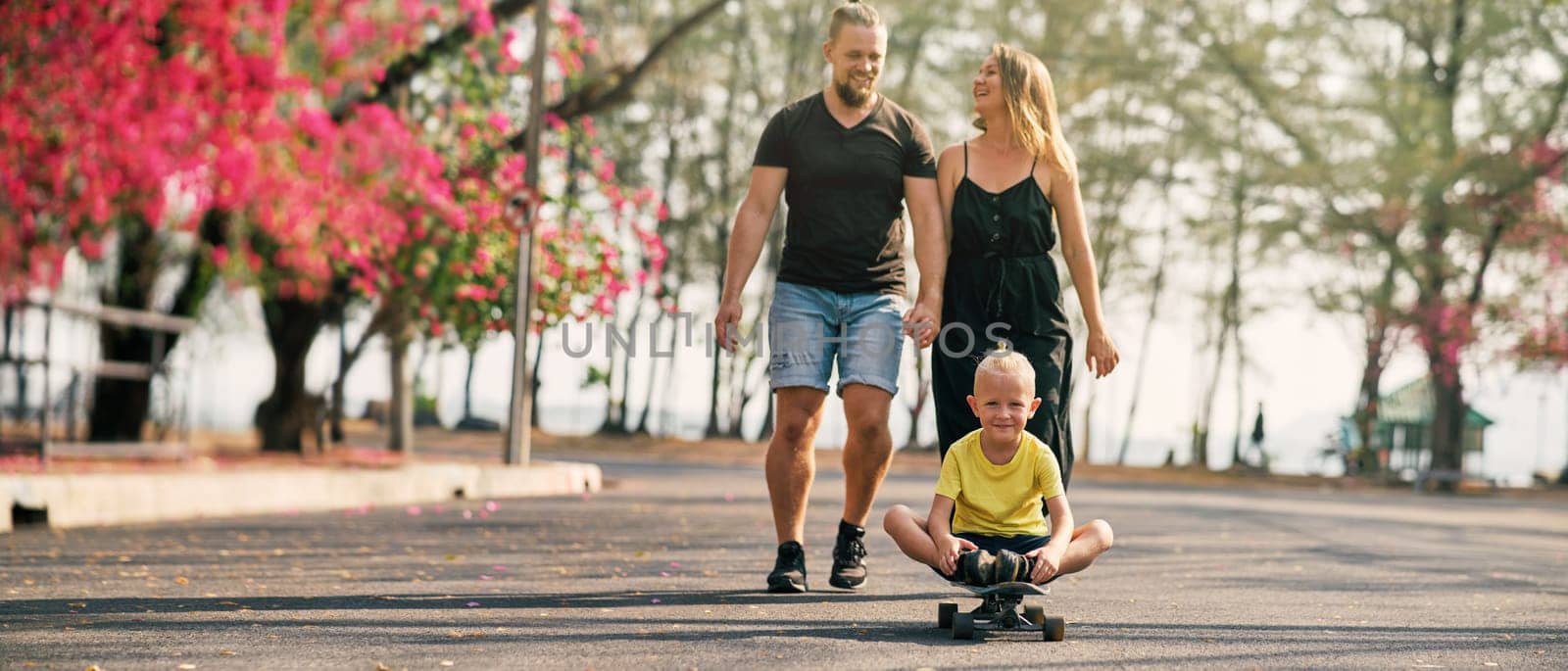Happy family of father, mother and son walking in blossoming spring park. End of quarantine. Banner