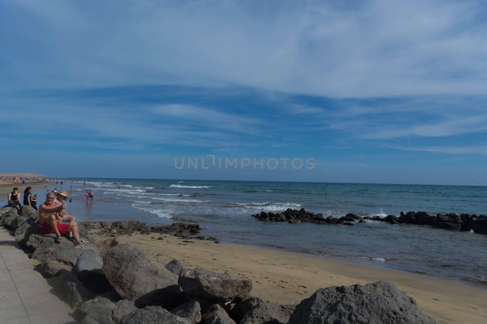 CRAN CANARIA, MELONERAS - NOVEMBER 13, 2019:.People enjoy the sea view and sit in the sun on the seafront of Meloneras on Gran Canaria, Spain