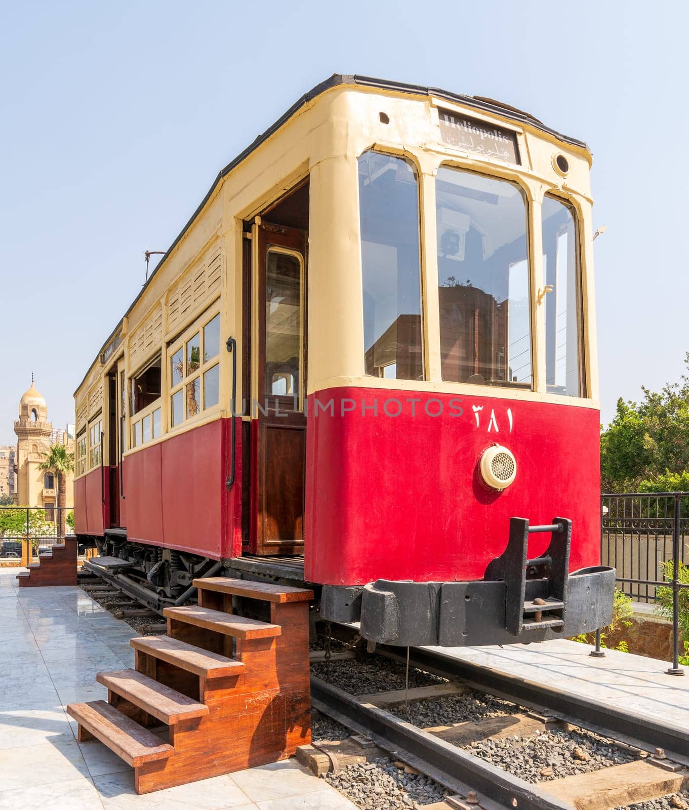 Exterior of vintage tram with wooden stairs near open doors located on rails on sunny day on town street