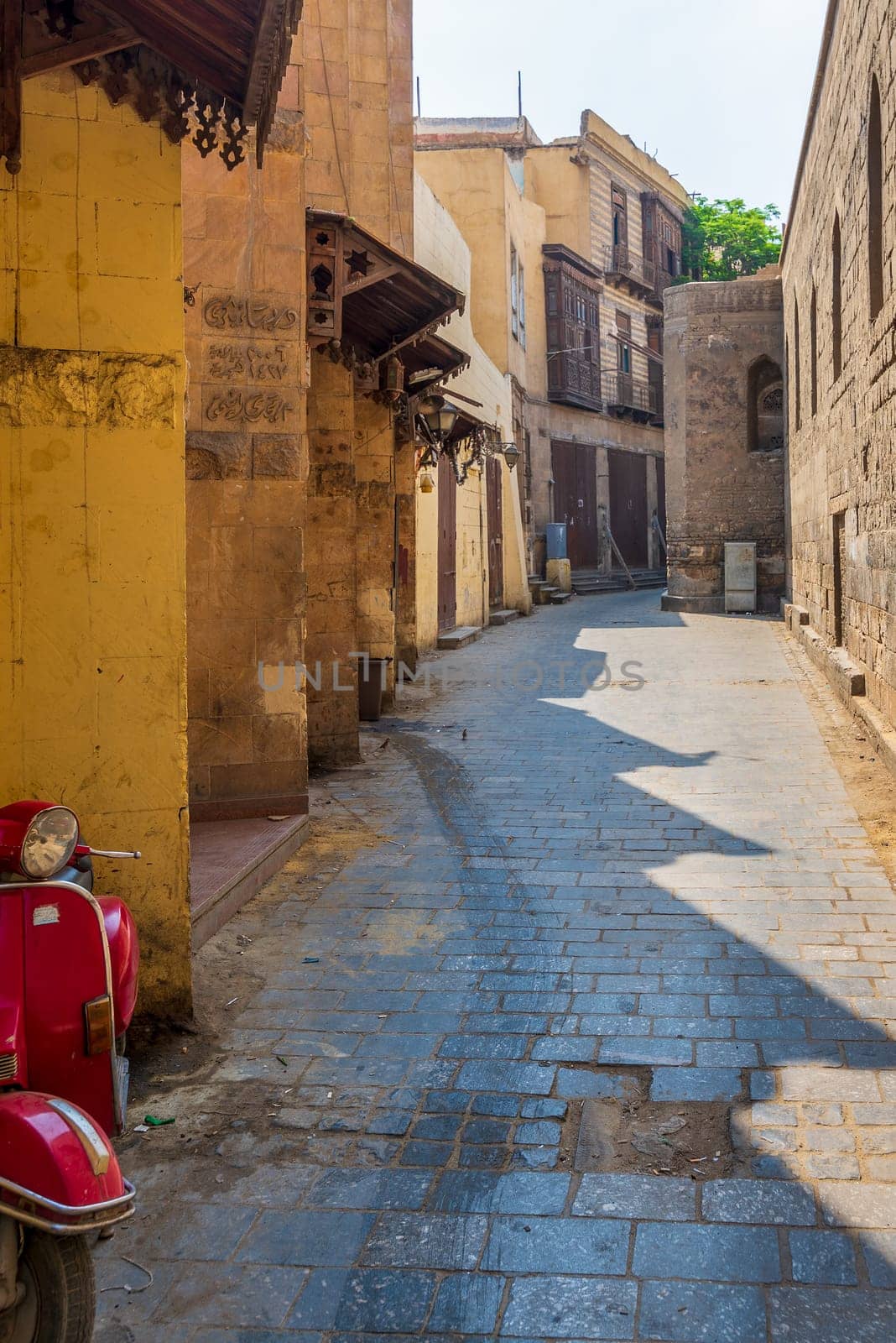 Cairo, Egypt - June 26 2020: Alley branching from historic Moez Street at Gamalia district, old Cairo, during Covid-19 lockdown period with closed shops and no pedestrians