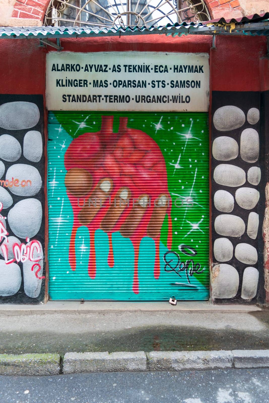 Istanbul, Turkey - April 18, 2017: Closed shop exterior with metal door covered with colorful graffiti at Hoca Tahsin Street, Karakoy district