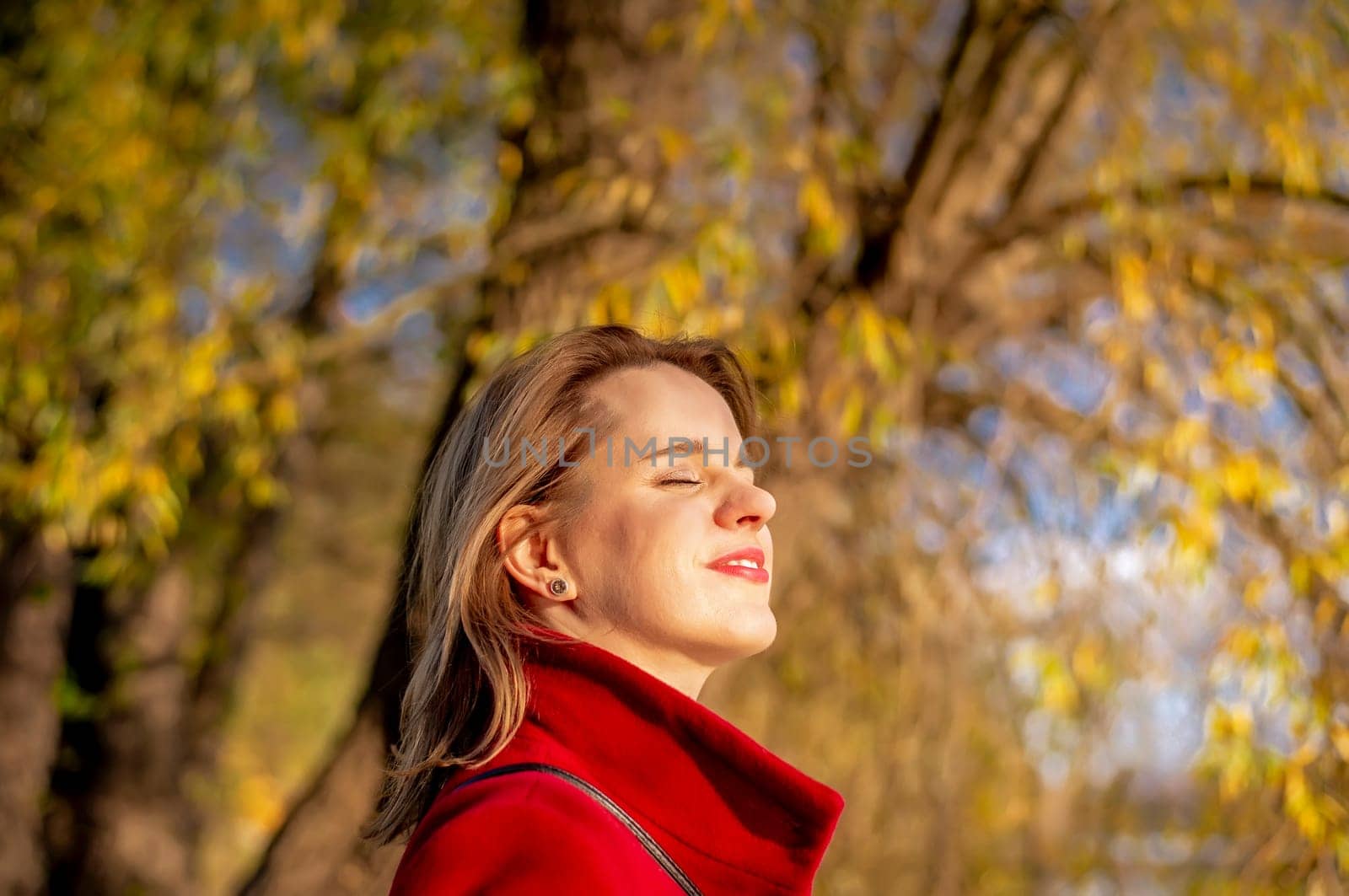 young woman enjoying evening sun in park