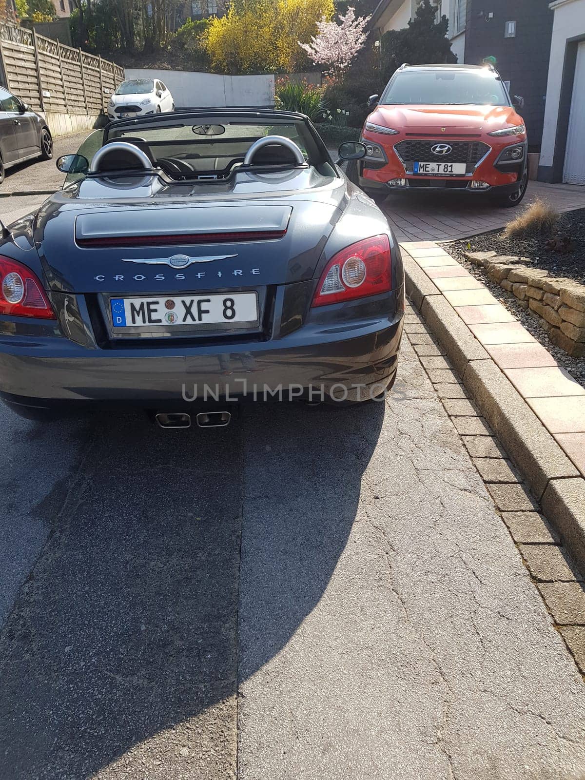 HEILIGENHAUS, NRW, GERMANY - MARCH 28, 2020:.A Hyundai Kona SUV and Chrysler Crossfire Roadster park in front of a house