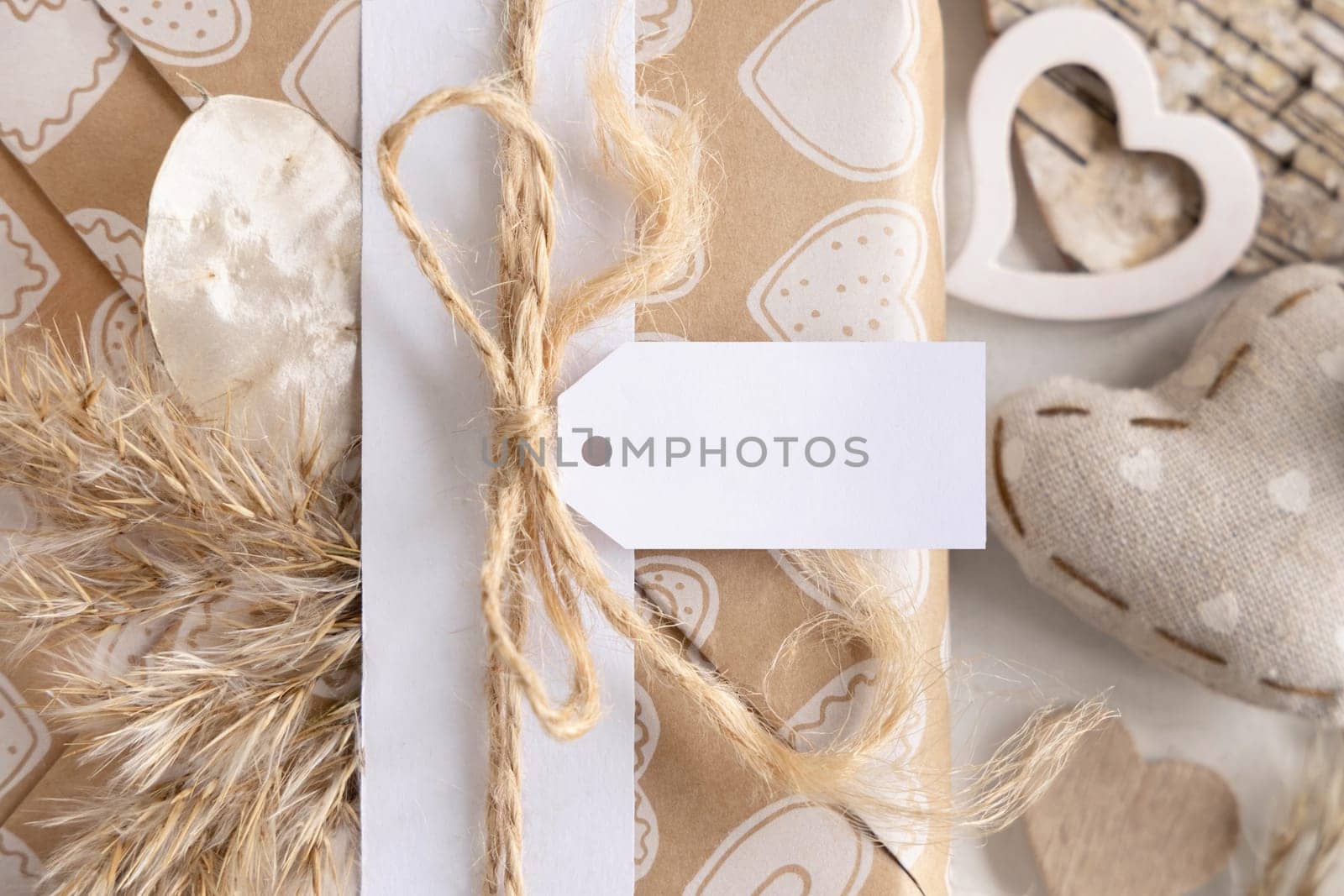 Valentines present with horizontal gift tag, heart and pampas grass close up. Spring scene with blank label. Rustic, cottage chic or bohemian mockup, copy space