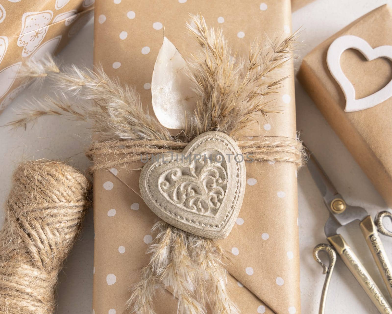 Valentines Day present wrapped in kraft paper and decorated with heart and pampass grass top view. Spring rustic, cottage chic or bohemian concept