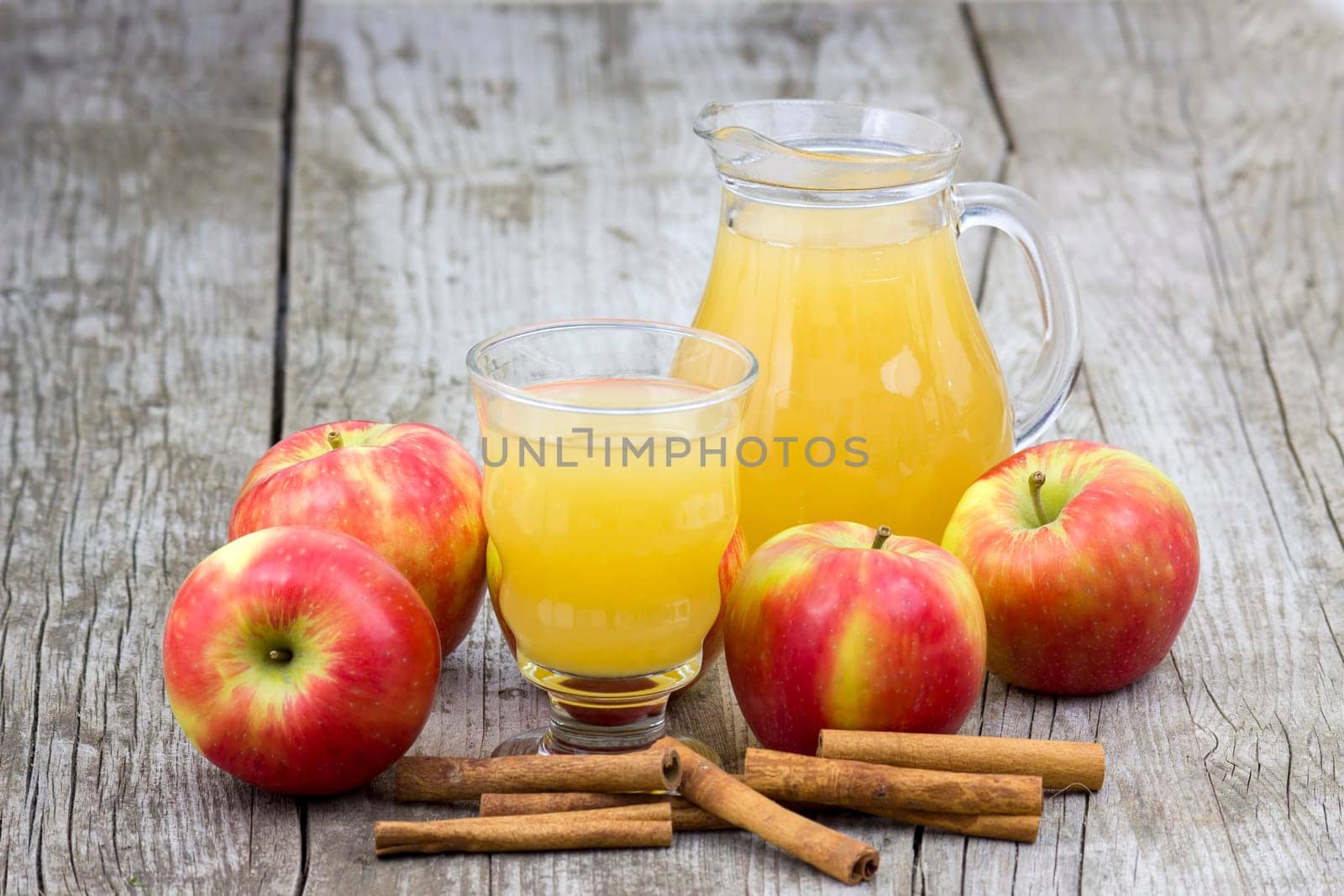 Apple juice and apples on wooden background
