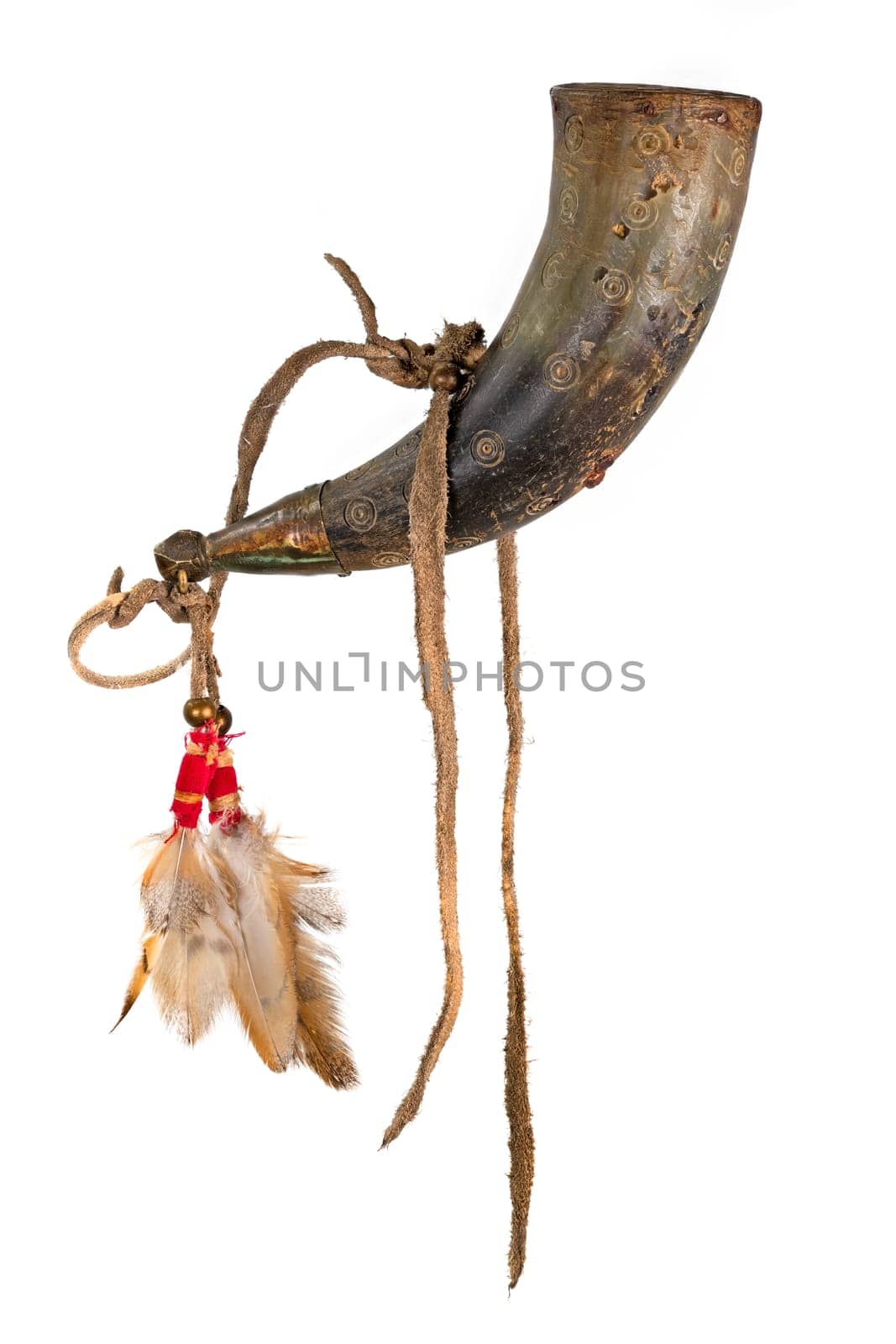 Old powder horn of the North American Indians made of horn decorated with deerskin and feathers isolated on white