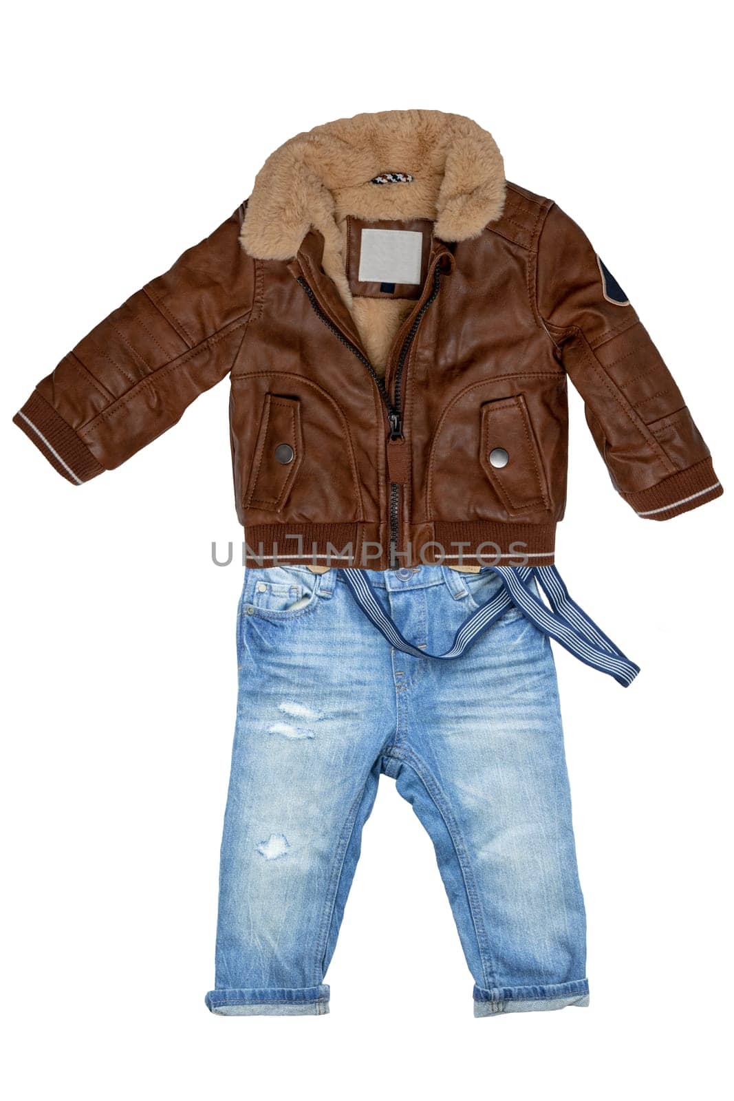 Closeup of a trendy stylish brown leather jacket with fur and a blue denim pants or trousers for child boy isolated on a white background. Jeans autumn fashion.