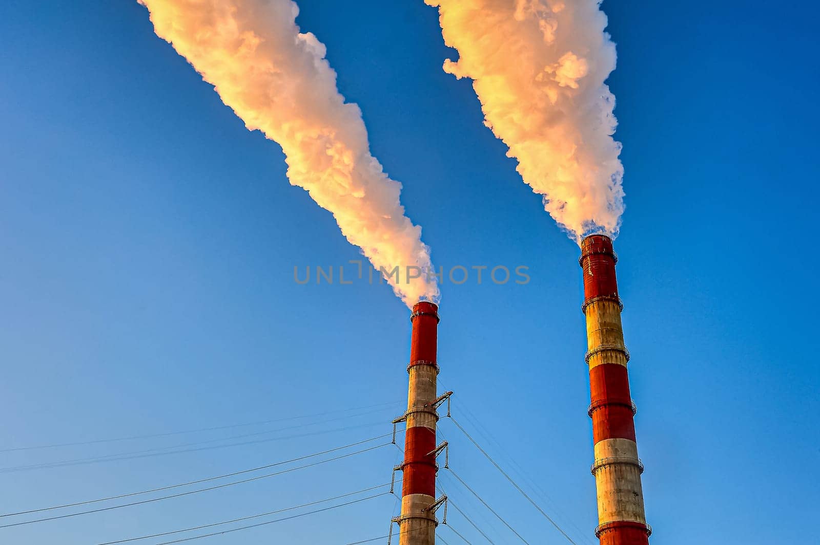 white smoke is coming out of the pipes in the blue sky. High quality photo