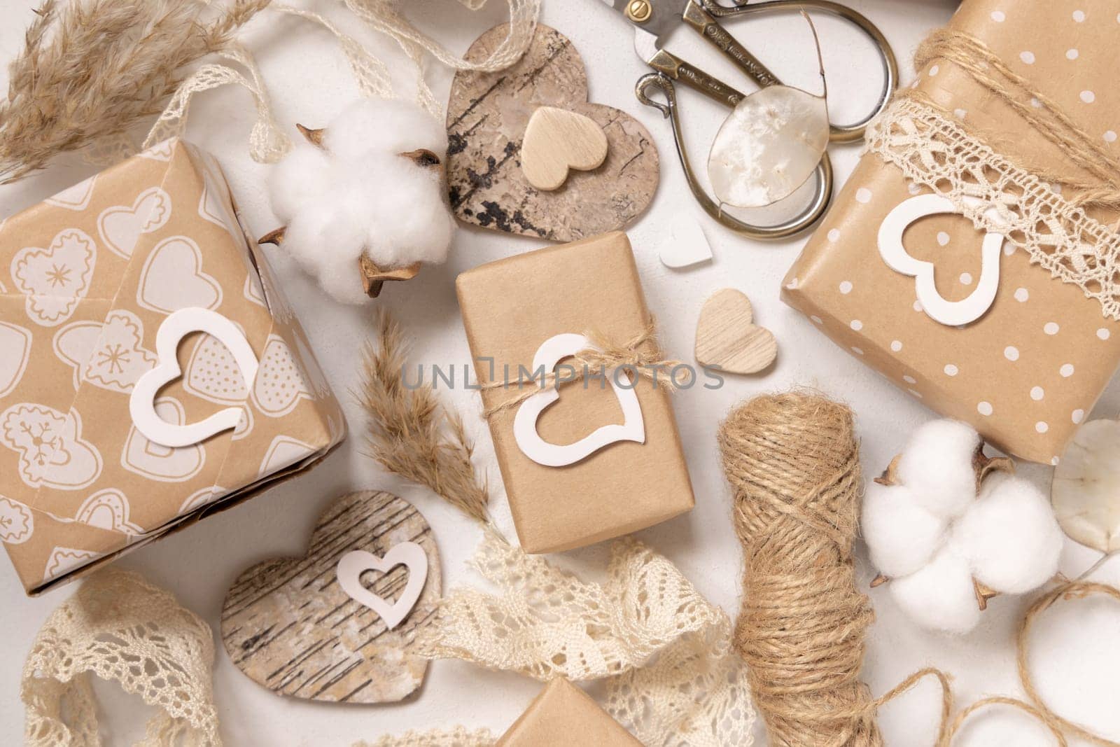 Valentines Day presents wrapped in kraft paper and decorated with vintage lace, hearts and pampass grass top view. Spring rustic, cottage chic or bohemian concept