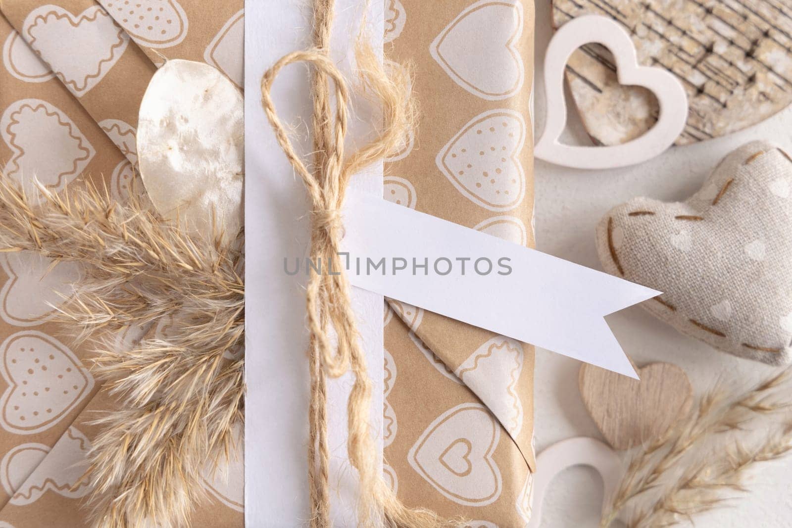 Valentines present with horizontal gift tag, heart and pampas grass close up. Spring scene with blank label. Rustic, cottage chic or bohemian mockup, copy space