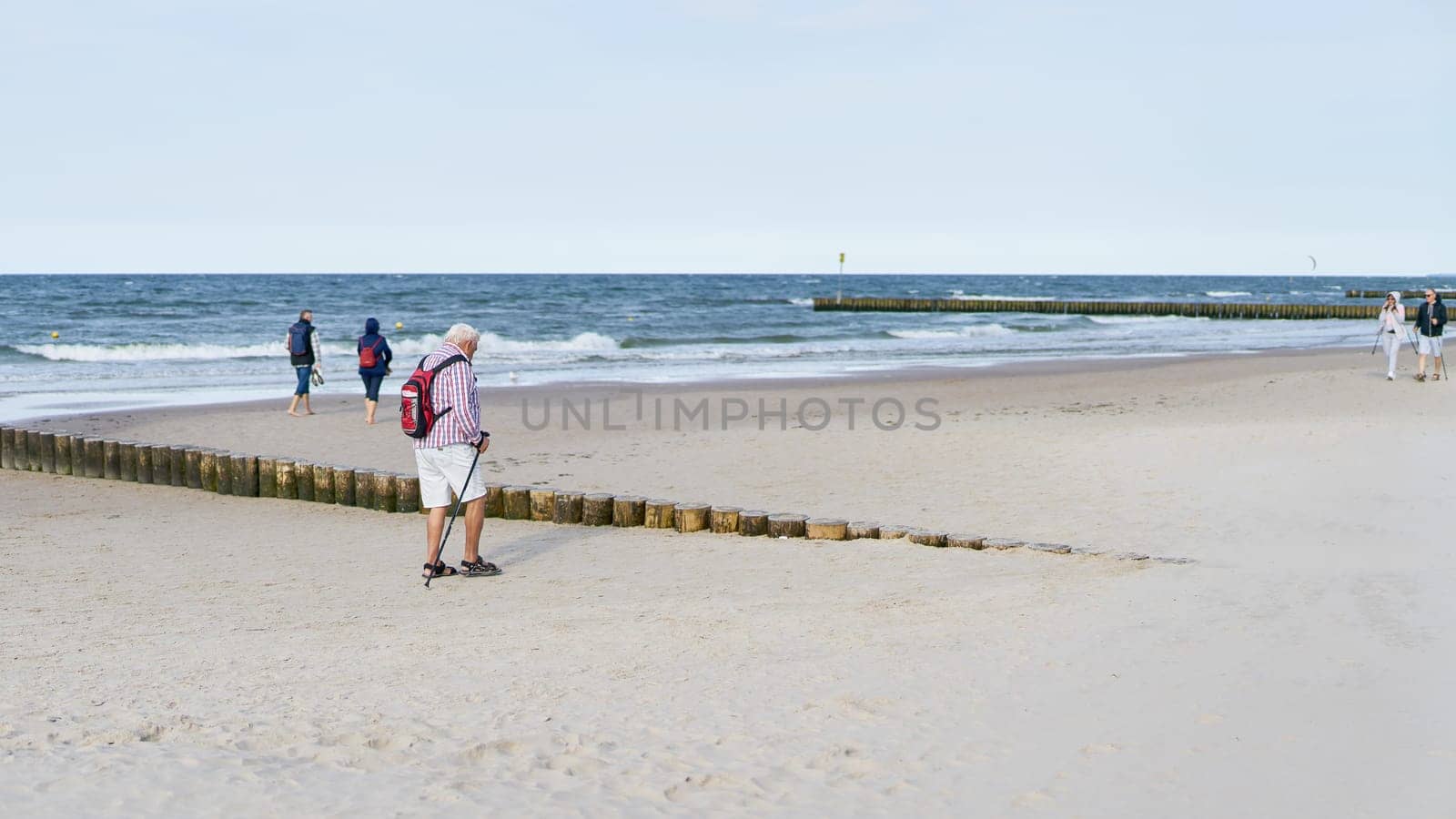 Strollers on the beach of Kolobrzeg on the Polish coast of the Baltic Sea