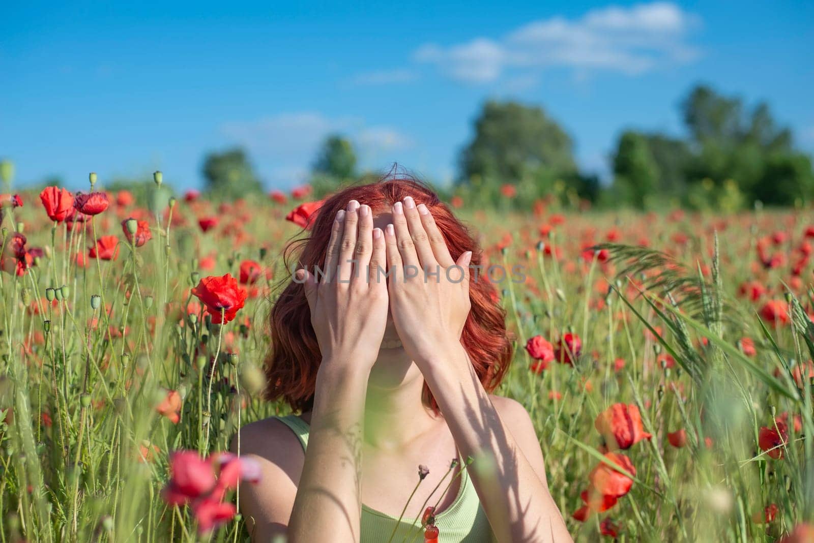 girl with red hairs covers her eyes